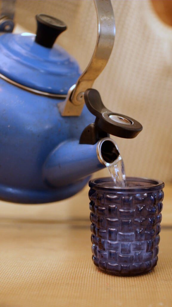 kettle-pouring-hot-water-into-empty-candle-jar