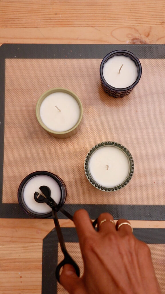 trimming-candle-wick-on-table-with-four-candles