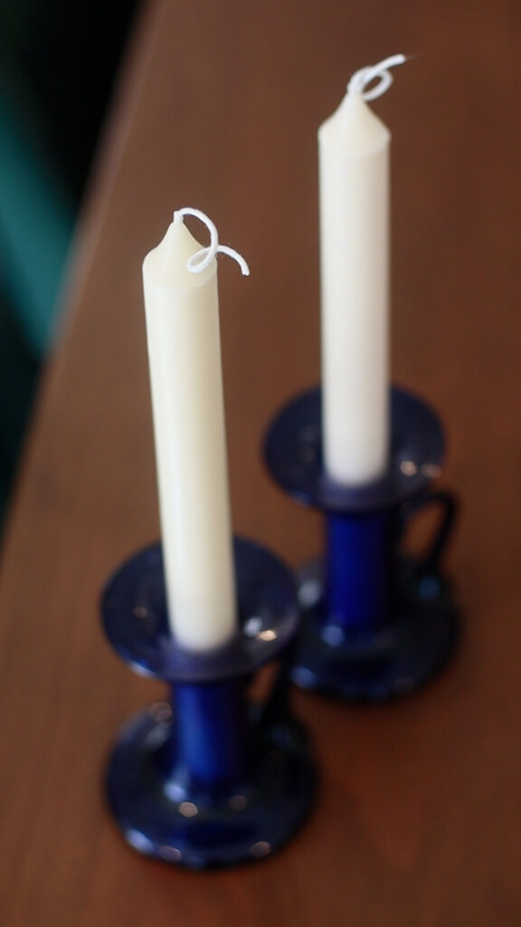 two-white-taper-candles-in-blue-taper-candle-holders