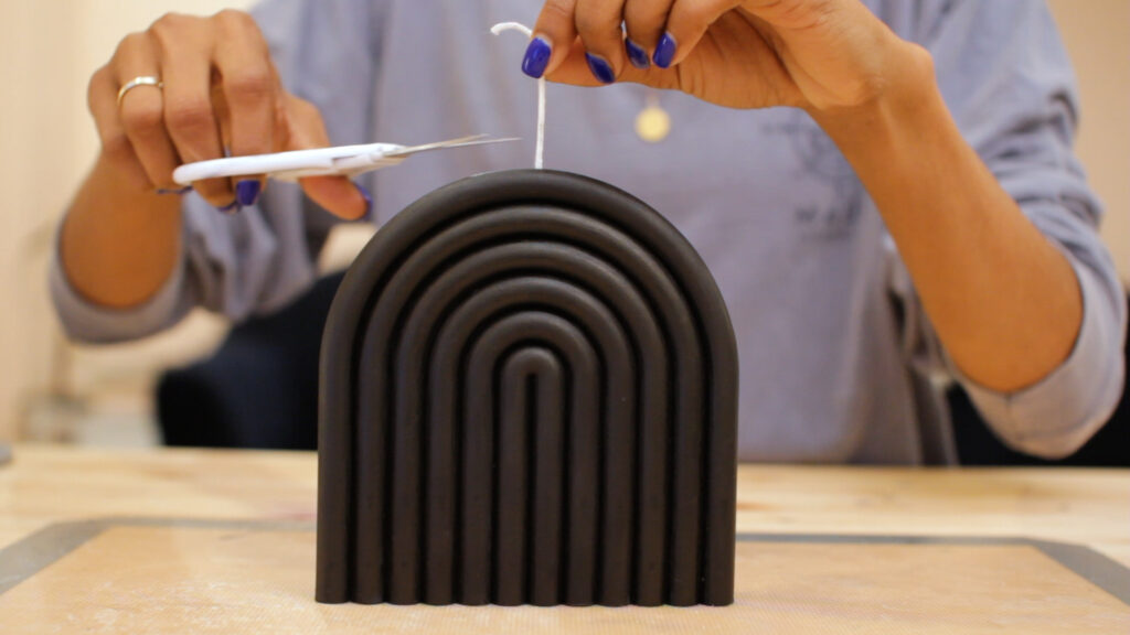 trimming-the-wick-of-a-black-arch-shaped-candle