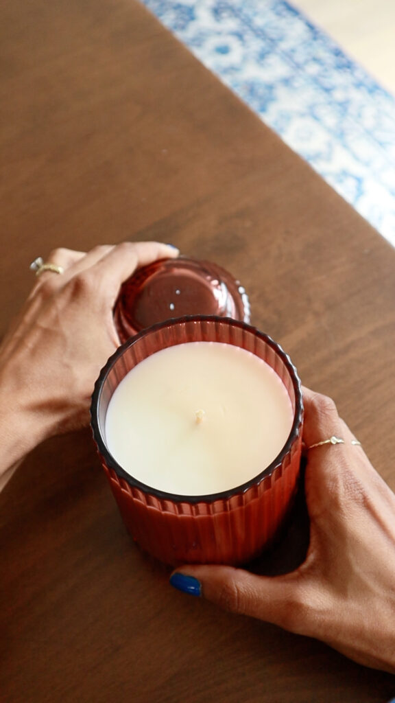 Overhead view of a pink glass La Jolie Muse Santal Rose candle jar.