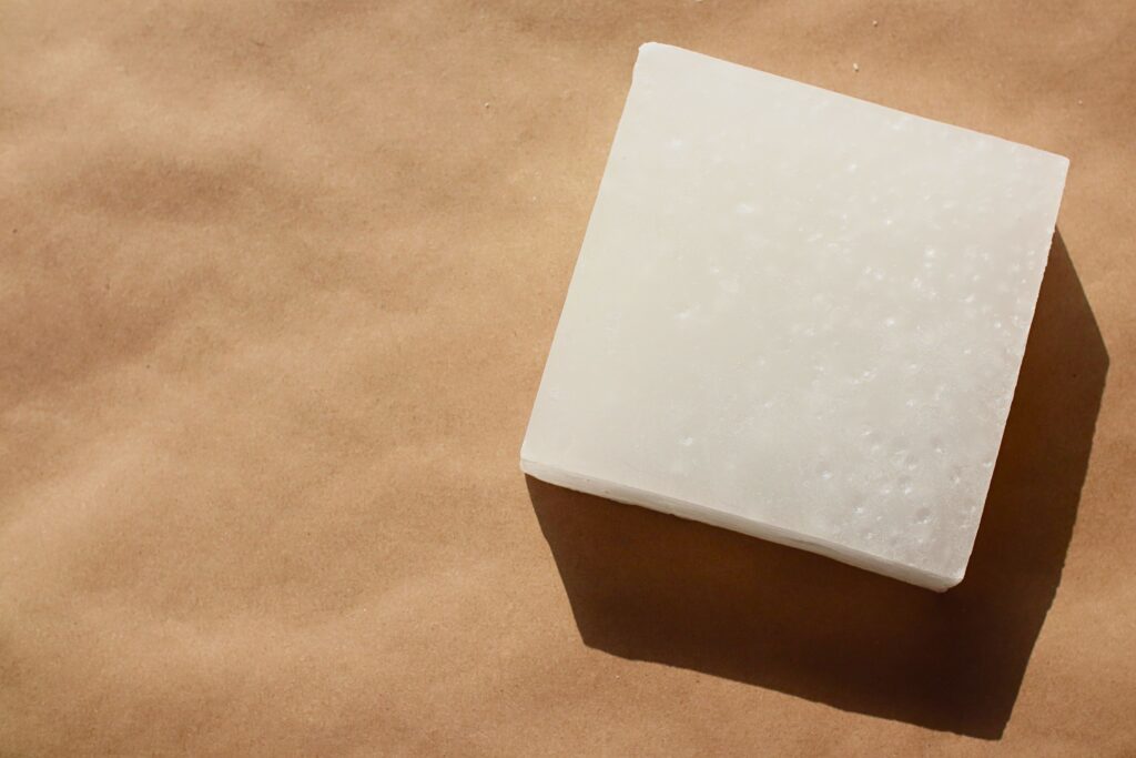 Block of paraffin wax on a piece of brown butcher paper.