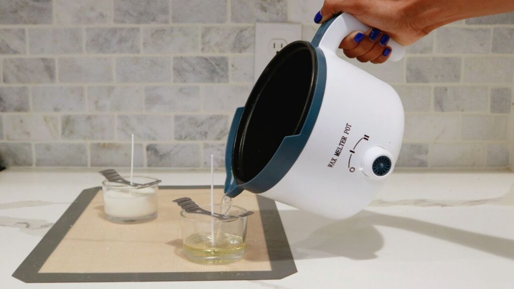 Hand pouring candle wax into a candle jar from a wax melter pot.