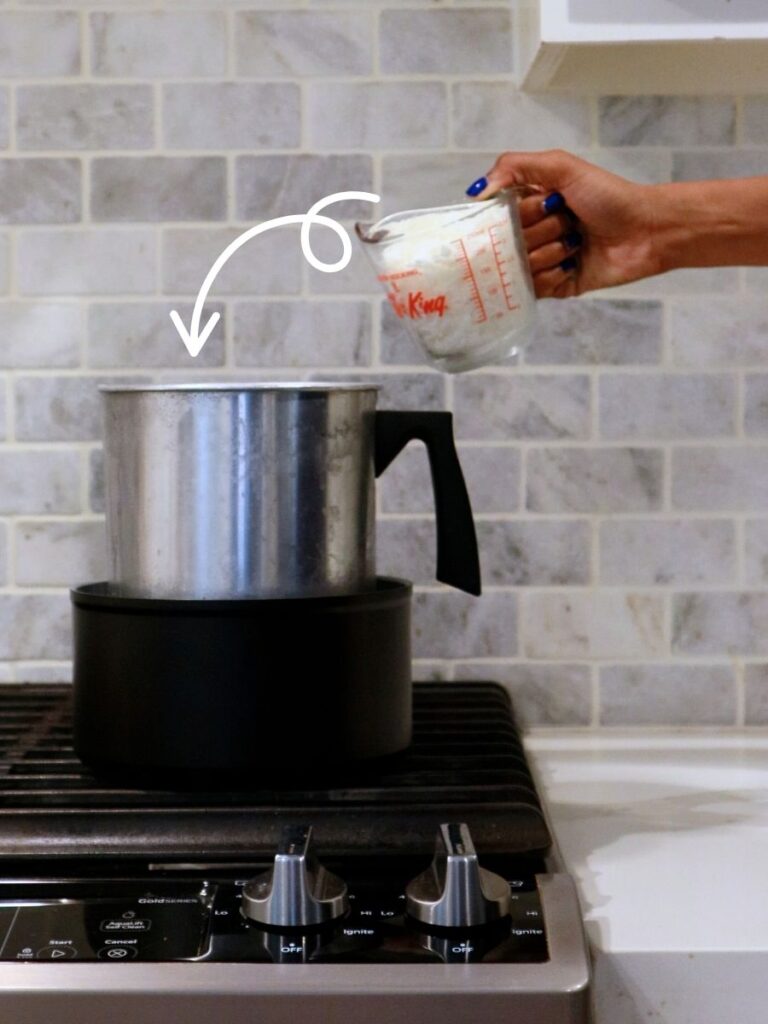 Pouring candle wax into a double boiler for melting candle wax.